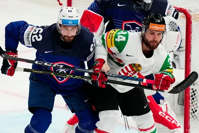 France's Florian Chakiachvili, left, and Hungary's Istvan Terbocs battle for the puck the group A match between France and Hungary at the ice hockey world championship in Tampere, Finland, Tuesday, May 16, 2023. (AP Photo/Pavel Golovkin)