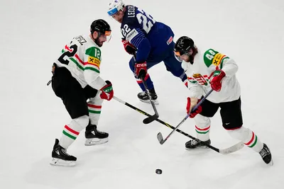 France's Guillaume Leclerc, centre, battles for the puck with Hungary's Bence Stipsicz, left, and Nandor Fejes during the group A match between France and Hungary at the ice hockey world championship in Tampere, Finland, Tuesday, May 16, 2023. (AP Photo/Pavel Golovkin)