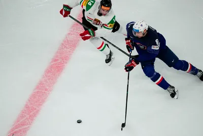 France's Hugo Gallet, right, and Hungary's Balazs Sebok battle for the puck during the group A match between France and Hungary at the ice hockey world championship in Tampere, Finland, Tuesday, May 16, 2023. (AP Photo/Pavel Golovkin)