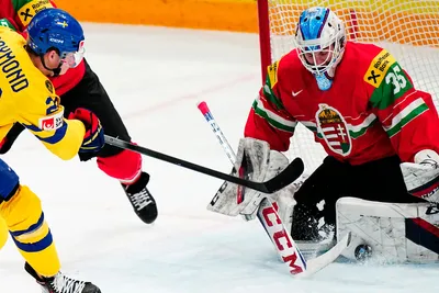 Sweden's Lucas Raymond, left, tries to score past Hungary's goalie Dominik Horvath during the group A match between Hungary and Sweden at the ice hockey world championship in Tampere, Finland, Thursday, May 18, 2023. (AP Photo/Pavel Golovkin)