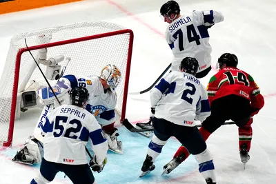 Hungary's Balazs Sebok, right, scores his side's first goal past Finland's goalie Jussi Olkinuora during the group A match between Hungary and Finland at the ice hockey world championship in Tampere, Finland, Friday, May 19, 2023. (AP Photo/Pavel Golovkin)
