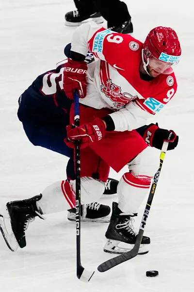 Denmark's Federik Storm, right, and United States Scott Perunovich battle for the puck during the group A match between United States and Denmark at the ice hockey world championship in Tampere, Finland, Saturday, May 20, 2023. (AP Photo/Pavel Golovkin)