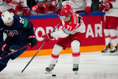 Denmark's Niklas Andersen, centre, and United States Nick Perbix battle for the puck during the group A match between United States and Denmark at the ice hockey world championship in Tampere, Finland, Saturday, May 20, 2023. (AP Photo/Pavel Golovkin)