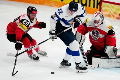 Finland's Kasperi Kapanen, centre, battles for the puck with Austria's goalie David Madlener, right, and Nico Brunner during the group A match between Austria and Finland at the ice hockey world championship in Tampere, Finland, Saturday, May 20, 2023. (AP Photo/Pavel Golovkin)