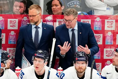 Finland's head coach Jukka Jalonen, right, and Finlands assistant coach Mikko Manner talk to players during the group A match between Austria and Finland at the ice hockey world championship in Tampere, Finland, Saturday, May 20, 2023. (AP Photo/Pavel Golovkin)