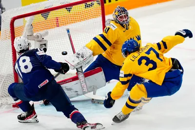 Sweden's goalie Lars Johansson, top, saves a shot by France's Dylan Fabre, left, during the group A match between Sweden and France at the ice hockey world championship in Tampere, Finland, Saturday, May 20, 2023. (AP Photo/Pavel Golovkin)