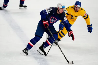 France's Justin Addamo, centre, and Sweden's Henrik Tommernes battle for the puck during the group A match between Sweden and France at the ice hockey world championship in Tampere, Finland, Saturday, May 20, 2023. (AP Photo/Pavel Golovkin)