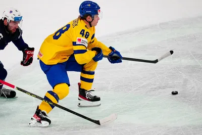 Sweden's Jonatan Berggren, centre, and France's Kevin Bozon battle for the puck during the group A match between Sweden and France at the ice hockey world championship in Tampere, Finland, Saturday, May 20, 2023. (AP Photo/Pavel Golovkin)