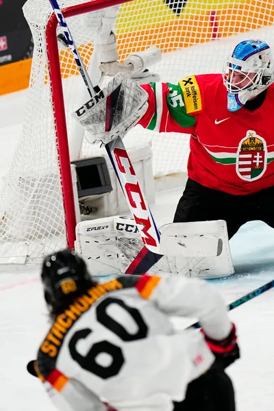 Germany's Wojciech Stachowiak, bottom, scores the opening goal past Hungary's goalie Dominik Horvath during the group A match between Germany and Hungary at the ice hockey world championship in Tampere, Finland, Sunday, May 21, 2023. (AP Photo/Pavel Golovkin)