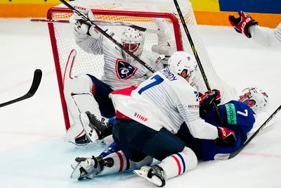 United States Ronnie Attard, right, battles for the puck with France's Pierre Crinon, centre, and France's goalie Sebastian Ylonen during the group A match between United States and France at the ice hockey world championship in Tampere, Finland, Sunday, May 21, 2023. (AP Photo/Pavel Golovkin)