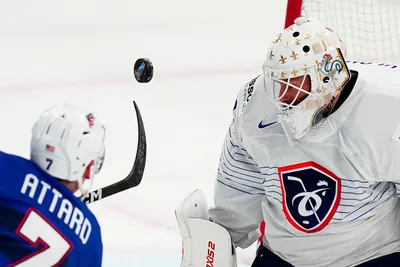 France's goalie Sebastian Ylonen, right, saves a shot by United States Ronnie Attard during the group A match between United States and France at the ice hockey world championship in Tampere, Finland, Sunday, May 21, 2023. (AP Photo/Pavel Golovkin)
