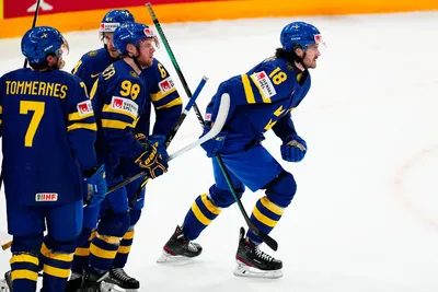 Sweden's Dennis Everberg, right, celebrates with teammates after scoring his side's first goal during the group A match between Denmark and Sweden at the ice hockey world championship in Tampere, Finland, Monday, May 22, 2023. (AP Photo/Pavel Golovkin)