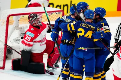 Sweden's team players celebrate after Dennis Everberg scored his side's first goal past Denmark's goalie George Sorensen, left, during the group A match between Denmark and Sweden at the ice hockey world championship in Tampere, Finland, Monday, May 22, 2023. (AP Photo/Pavel Golovkin)