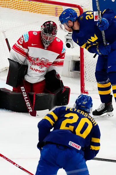 Sweden's Andre Petersson, bottom, scores his side's second goal past Denmark's goalie George Sorensen during the group A match between Denmark and Sweden at the ice hockey world championship in Tampere, Finland, Monday, May 22, 2023. (AP Photo/Pavel Golovkin)