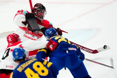 Denmark's goalie George Sorensen, top, makes a save during the group A match between Denmark and Sweden at the ice hockey world championship in Tampere, Finland, Monday, May 22, 2023. (AP Photo/Pavel Golovkin)