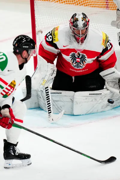 Hungary's Istvan Sofron, left, scores his side's second goal past Austria's goalie Bernhard Starkbaum during the group A match between Austria and Hungary at the ice hockey world championship in Tampere, Finland, Monday, May 22, 2023. (AP Photo/Pavel Golovkin)