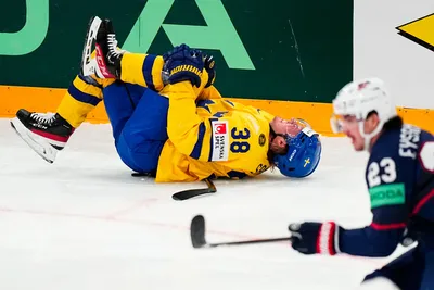 Sweden's Rasmus Sandin lays in pain after a battle with United States Michael Eyssimont, right, during the group A match between Sweden and United States at the ice hockey world championship in Tampere, Finland, Tuesday, May 23, 2023. (AP Photo/Pavel Golovkin)