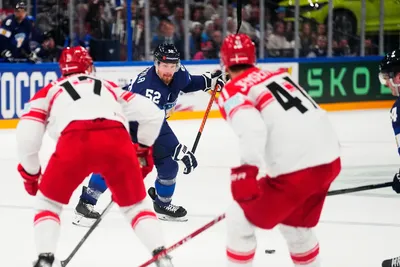 Finland's Mikael Seppala, centre, passes to Ville Pokka to score his side's third goal during the group A match between Finland and Denmark at the ice hockey world championship in Tampere, Finland, Tuesday, May 23, 2023. (AP Photo/Pavel Golovkin)
