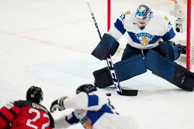 Canada's Jack Quinn, bottom left, scores the opening goal past Finland's goalie Emil Larmi during the quarterfinal match between Canada and Finland at the ice hockey world championship in Tampere, Finland, Thursday, May 25, 2023. (AP Photo/Pavel Golovkin)
