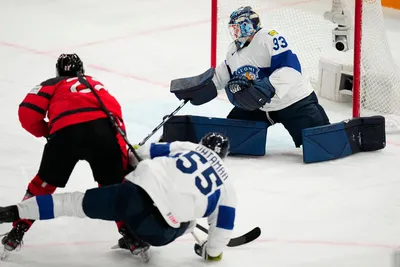 Canada's Jack Quinn, left, scores the opening goal past Finland's goalie Emil Larmi during the quarterfinal match between Canada and Finland at the ice hockey world championship in Tampere, Finland, Thursday, May 25, 2023. (AP Photo/Pavel Golovkin)