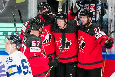 Canada's Jack Quinn, centre, celebrates with teammates after scoring the opening goal during the quarterfinal match between Canada and Finland at the ice hockey world championship in Tampere, Finland, Thursday, May 25, 2023. (AP Photo/Pavel Golovkin)
