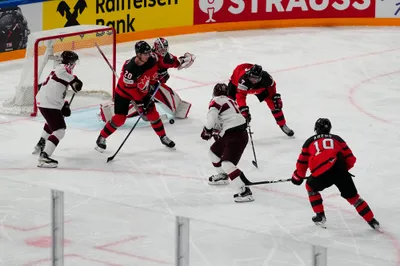 Latvia's Rodrigo Abols feed the puck to Dans Locmelis (85) as Canada's Justin Barron (20) and Canada's Pierre-Olivier Joseph (7) defend during their semifinal match at the Ice Hockey World Championship in Tampere, Finland, Saturday, May 27, 2023. (AP Photo/Pavel Golovkin)