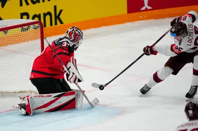 Latvia's Dans Locmelis (85) shoots against Canada's goalie Samuel Montembeault (35) during their semifinal match at the Ice Hockey World Championship in Tampere, Finland, Saturday, May 27, 2023. (AP Photo/Pavel Golovkin)