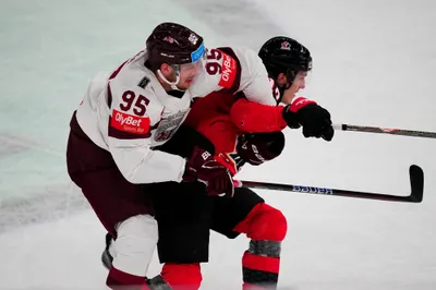 Latvia's Oskars Batna (95) and Canada's Peyton Krebs battle during their semifinal match at the Ice Hockey World Championship in Tampere, Finland, Saturday, May 27, 2023. (AP Photo/Pavel Golovkin)