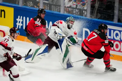 Latvia's goalie Arturs Silovs (31) leaves the net to defend against Canada's Adam Fantilli (91) and Milan Lucic (17) during their semifinal match at the Ice Hockey World Championship in Tampere, Finland, Saturday, May 27, 2023. (AP Photo/Pavel Golovkin)