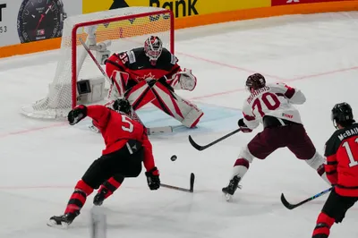 Latvia's Miks Indrasis (70) shoots against Canada's goalie Samuel Montembeault (35) during their semifinal match at the Ice Hockey World Championship in Tampere, Finland, Saturday, May 27, 2023. (AP Photo/Pavel Golovkin)