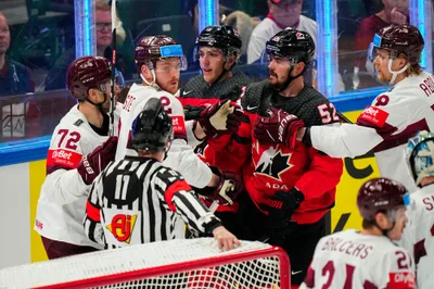 Latvia (white) and Canada scuffle during their semifinal match at the Ice Hockey World Championship in Tampere, Finland, Saturday, May 27, 2023. (AP Photo/Pavel Golovkin)