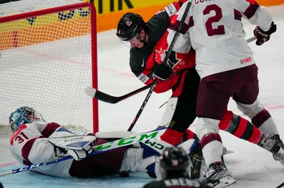 Latvia's goalie Arturs Silovs (31) falls to the ice while battling Canada's Cody Glass (8) during their semifinal match at the Ice Hockey World Championship in Tampere, Finland, Saturday, May 27, 2023. (AP Photo/Pavel Golovkin)