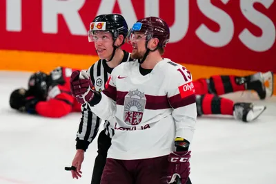 Latvia's Rihards Bukarts (13) talks to a referee as Canada's Jacob Middleton lies on the ice during their semifinal match at the Ice Hockey World Championship in Tampere, Finland, Saturday, May 27, 2023. (AP Photo/Pavel Golovkin)