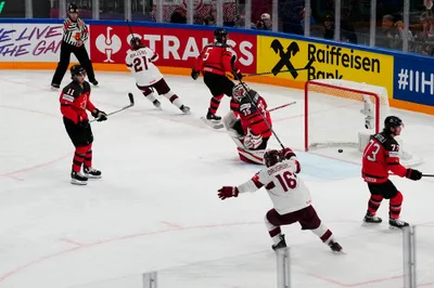 Latvia's Rudolfs Balcers (21) scores on Canada's goalie Samuel Montembeault (35) during their semifinal match at the Ice Hockey World Championship in Tampere, Finland, Saturday, May 27, 2023. (AP Photo/Pavel Golovkin)