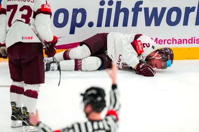 Latvia's Karlis Cukste (2) lies on the ice after being hurt in their bronze medal match against the United States at the Ice Hockey World Championship in Tampere, Finland, Sunday, May 28, 2023. (AP Photo/Pavel Golovkin)