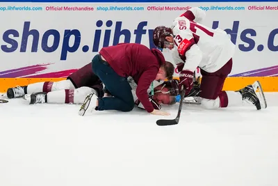 Latvia's Karlis Cukste (2) is tended to after being hurt in their bronze medal match against the United States at the Ice Hockey World Championship in Tampere, Finland, Sunday, May 28, 2023. (AP Photo/Pavel Golovkin)