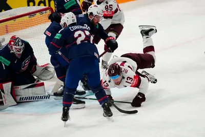 Latvia's Rihards Bukarts (13) falls to the ice as United States goalie Casey DeSmith (1) cannot stop the puck on a goal by Latvia's Janis Jaks, not pictured, in their bronze medal match at the Ice Hockey World Championship in Tampere, Finland, Sunday, May 28, 2023. (AP Photo/Pavel Golovkin)