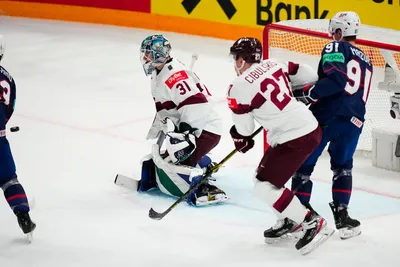 The puck shoots into the net past Latvia's goalie Arturs Silovs (31) on a goal by United States Rocco Grimaldi, not pictured, in their bronze medal match at the Ice Hockey World Championship in Tampere, Finland, Sunday, May 28, 2023. (AP Photo/Pavel Golovkin)