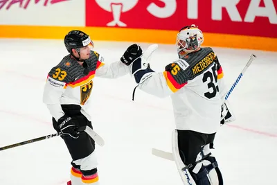 Germany's John Peterka (33) celebrates his goal with goalie Mathias Niederberger (35) during the gold medal match against Canada at the Ice Hockey World Championship in Tampere, Finland, Sunday, May 28, 2023. (AP Photo/Pavel Golovkin)