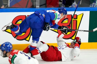 Patrik Koch of Slovakia, in blue, fights for a puck with Filip Chlapik of Czech Republic, in red, during the group B match between Slovakia and the Czech Republic at the ice hockey world championship in Riga, Latvia, Friday, May 12, 2023. (AP Photo/Roman Koksarov)