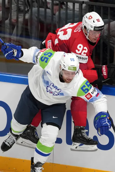 Gaetan Haas of Switzerland, right, fights for a puck with Robert Sabolic of Slovenia during the group B match between Switzerland and Slovenia at the ice hockey world championship in Riga, Latvia, Saturday, May 13, 2023. (AP Photo/Roman Koksarov)