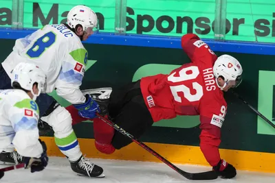 Gaetan Haas of Switzerland, right, fights for a puck with Ziga Jeglic of Slovenia during the group B match between Switzerland and Slovenia at the ice hockey world championship in Riga, Latvia, Saturday, May 13, 2023. (AP Photo/Roman Koksarov)