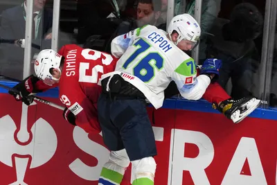 Dario Simion of Switzerland, left, fights for a puck with Kristjan Cepon of Slovenia during the group B match between Switzerland and Slovenia at the ice hockey world championship in Riga, Latvia, Saturday, May 13, 2023. (AP Photo/Roman Koksarov)