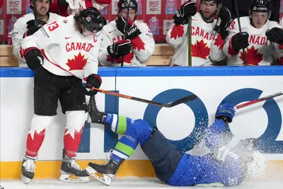 Ziga Jeglic of Slovenia, right, fights for a puck with Tyler Toffoli of Canada during the group B match between Slovenia and Canada at the ice hockey world championship in Riga, Latvia, Sunday, May 14, 2023. (AP Photo/Roman Koksarov)