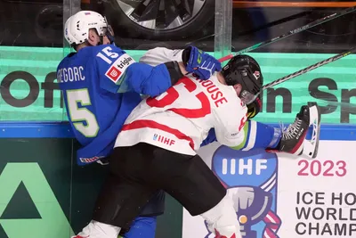 Blaz Gregorc of Slovenia, left, fights for a puck with Lawson Crouse of Canada during the group B match between Slovenia and Canada at the ice hockey world championship in Riga, Latvia, Sunday, May 14, 2023. (AP Photo/Roman Koksarov)