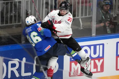 Bine Masic of Slovenia, left, fights for a puck with Scott Laughton of Canada during the group B match between Slovenia and Canada at the ice hockey world championship in Riga, Latvia, Sunday, May 14, 2023. (AP Photo/Roman Koksarov)
