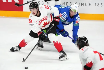 Robert Sabolic of Slovenia, right, fights for a puck with Jack Quinn of Canada during the group B match between Slovenia and Canada at the ice hockey world championship in Riga, Latvia, Sunday, May 14, 2023. (AP Photo/Roman Koksarov)