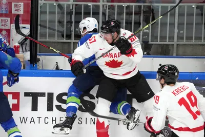 Miha Verlic of Slovenia, left, fights for a puck with Lawson Crouse of Canada during the group B match between Slovenia and Canada at the ice hockey world championship in Riga, Latvia, Sunday, May 14, 2023. (AP Photo/Roman Koksarov)