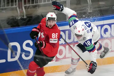 Thomas Olsen of Norway, right, fights for a puck with Janis Moser of Switzerland during the group B match between Norway and Switzerland at the ice hockey world championship in Riga, Latvia, Sunday, May 14, 2023. (AP Photo/Roman Koksarov)