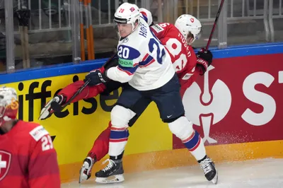 Ludvig Hoff of Norway, center, fights for a puck with Janis Moser of Switzerland during the group B match between Norway and Switzerland at the ice hockey world championship in Riga, Latvia, Sunday, May 14, 2023. (AP Photo/Roman Koksarov)